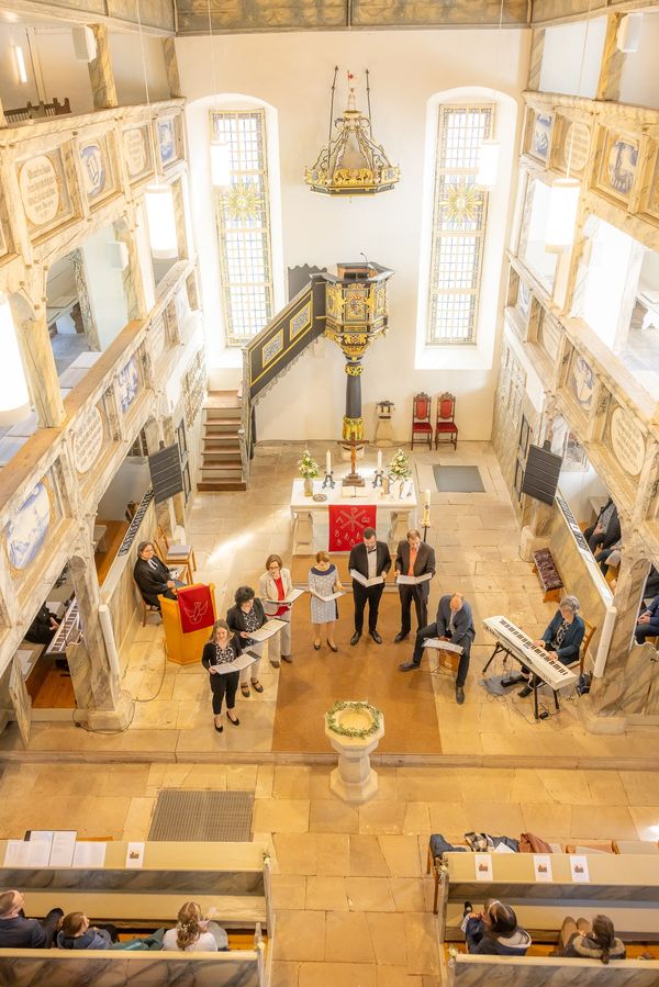 Innenraum der Marienkirche Breitungen mit bemalten Emporen und rotem Läufer